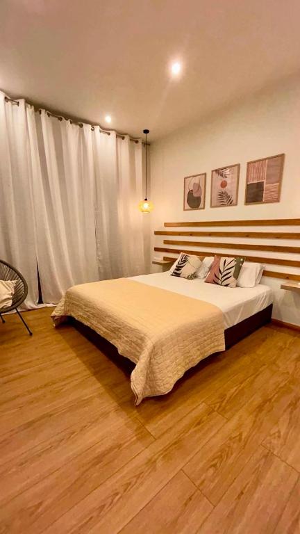 a bedroom with a large bed and a wooden floor at Stone Luxury Suite in Galatás
