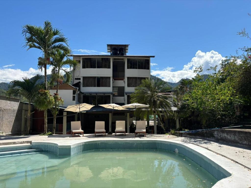 a hotel with a swimming pool in front of a building at Cerro Verde in San Ramón