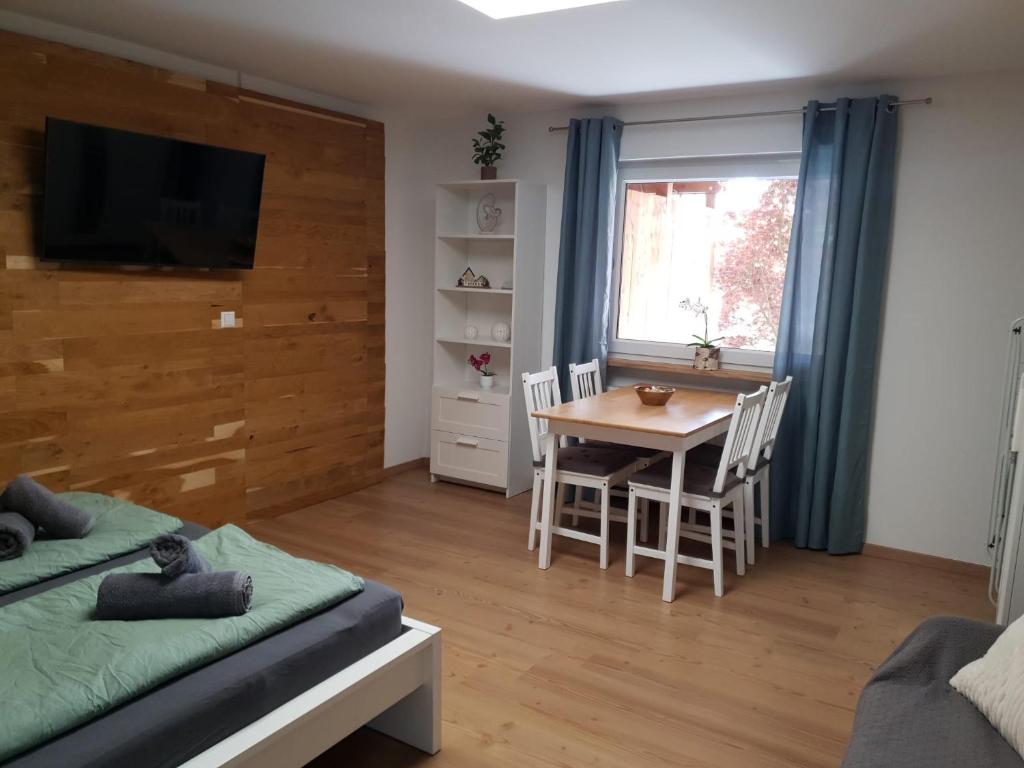a room with a table and a bed and a table and chairs at Anderer Apartment 2 in Liedolsheim