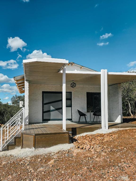 a house with a porch with a table and a chair at Orang Cottages BW in Ramotswa
