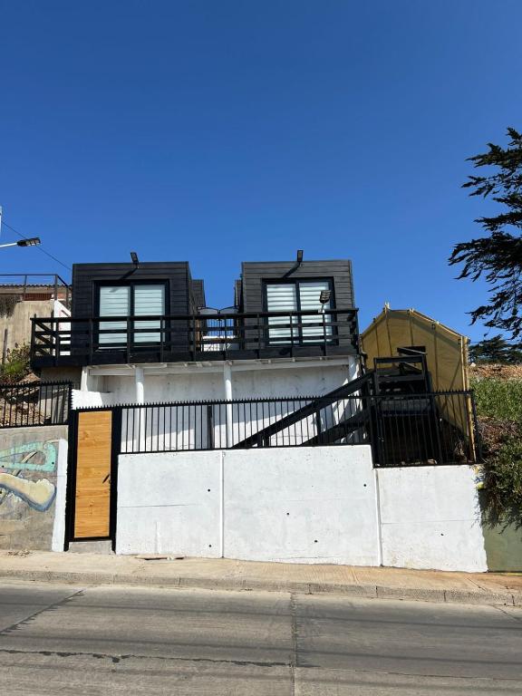 a building with a fence and a building with a gate at Cabañas Vista Mar in Los Vilos