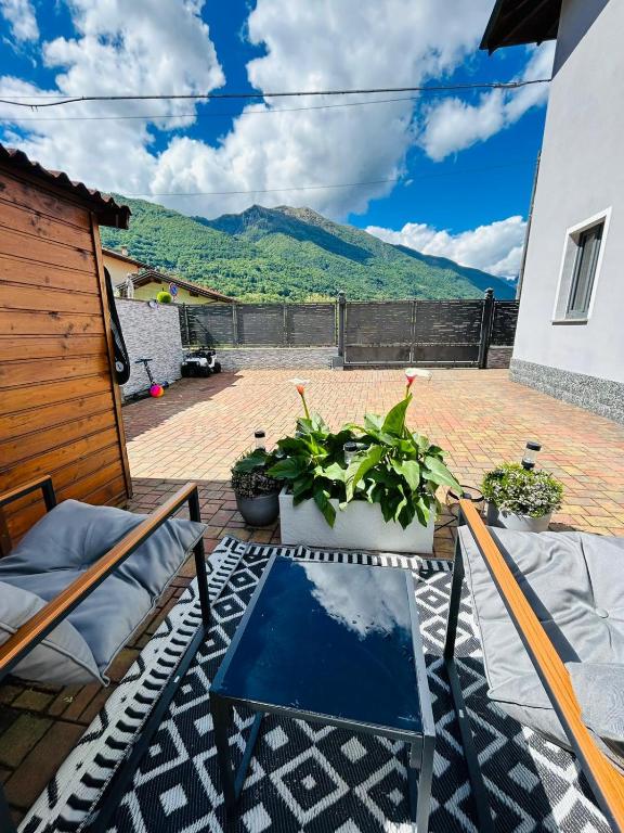 a patio with a table and chairs and a mountain at Villa Felix in Omegna
