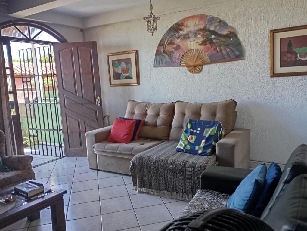 a living room with a couch and a table at Férias pé na areia, sol e mar in Serra
