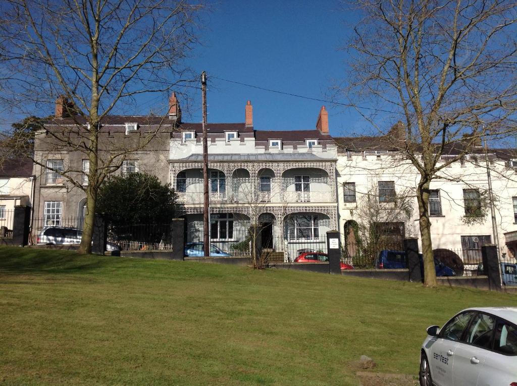 ein weißes Auto, das vor einem großen Gebäude parkt in der Unterkunft 8a Spring Gardens in Haverfordwest