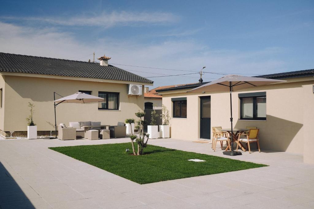 a yard with a patio with a table and an umbrella at Villa d'Avó Dalva in Vila Chã