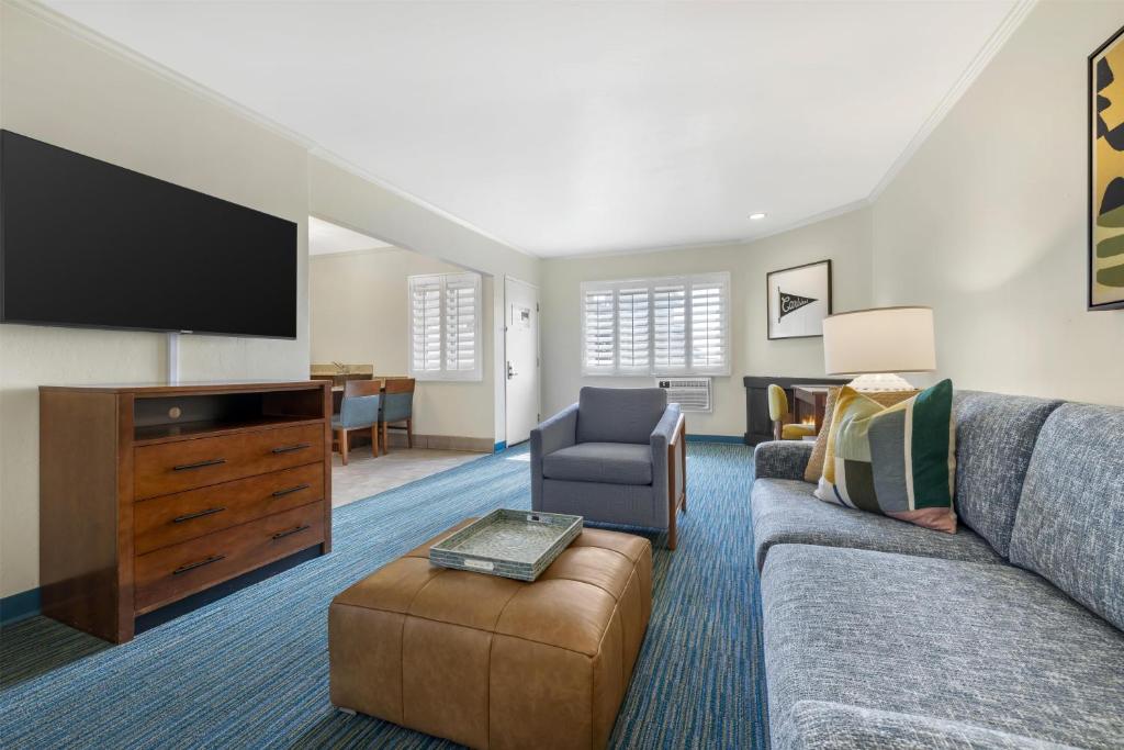 a living room with a couch and a flat screen tv at Best Western Plus Beach View Lodge Carlsbad in Carlsbad