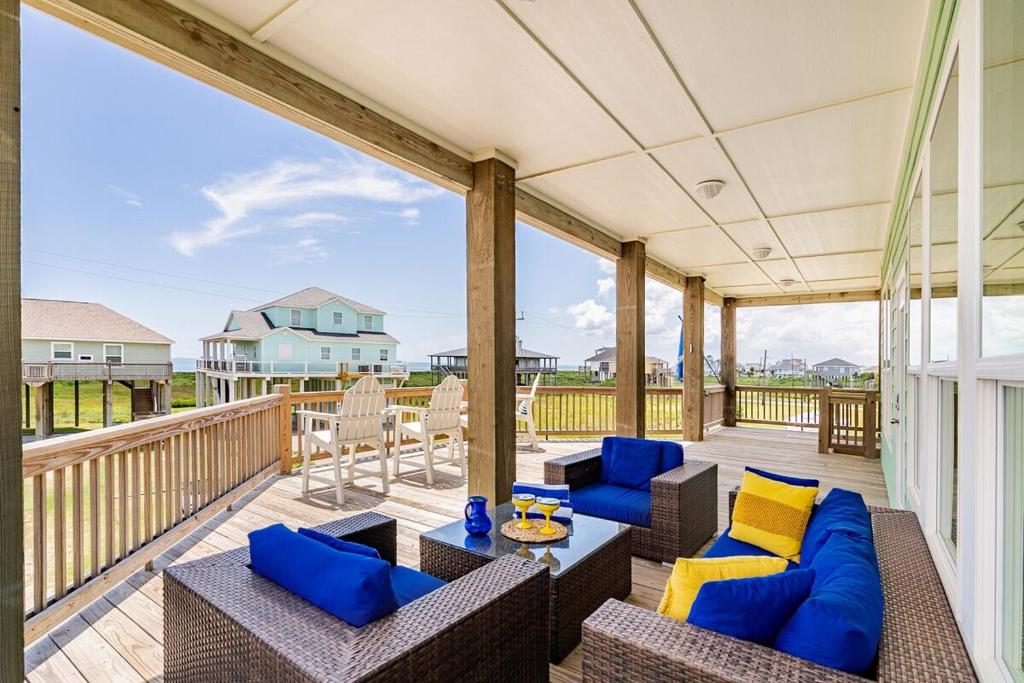 a patio with couches and chairs on a deck at King Bed, Beach Views, The Salt Surf Shack in Bolivar Peninsula
