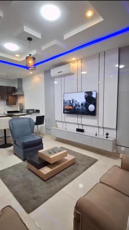 a living room with a couch and a tv at Chic Shop House in Abomey-Calavi
