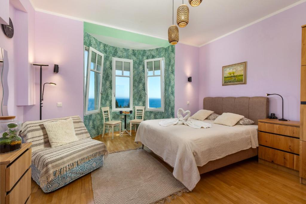 a bedroom with a bed and a chair and windows at Blue Horizon Studio Opatija in Opatija