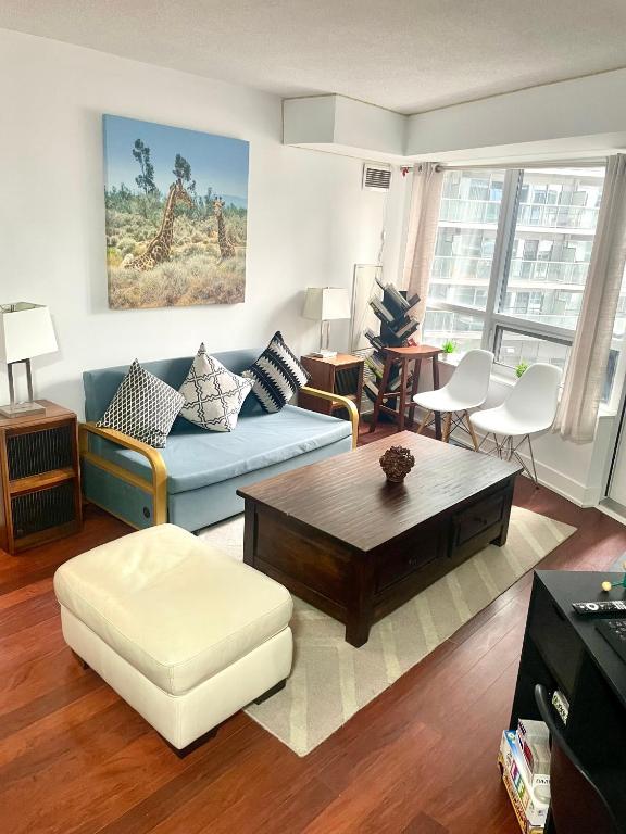 a living room with a blue couch and a coffee table at Core Downtown Toronto-8 Sleeper-4 Beds-2 Bathrooms-Washrooms-Free Parking-CN Tower-Ripleys Museum-Blue Jays Stadium In front-Indoor Gym-Swimming Pool-Jacuzzi Sauna-Filter Drinking Water-WiFi in Toronto