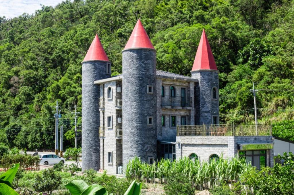 an old castle with red turrets on top of it at Zum Adler Castle B&B in Jiaoxi