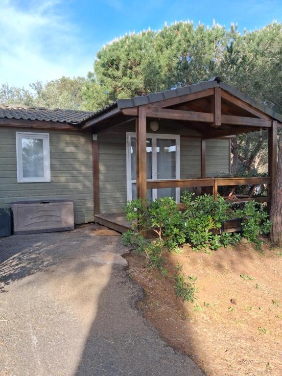 a house with a covered porch in front of it at Chalet climatisé 6 personnes in Agde