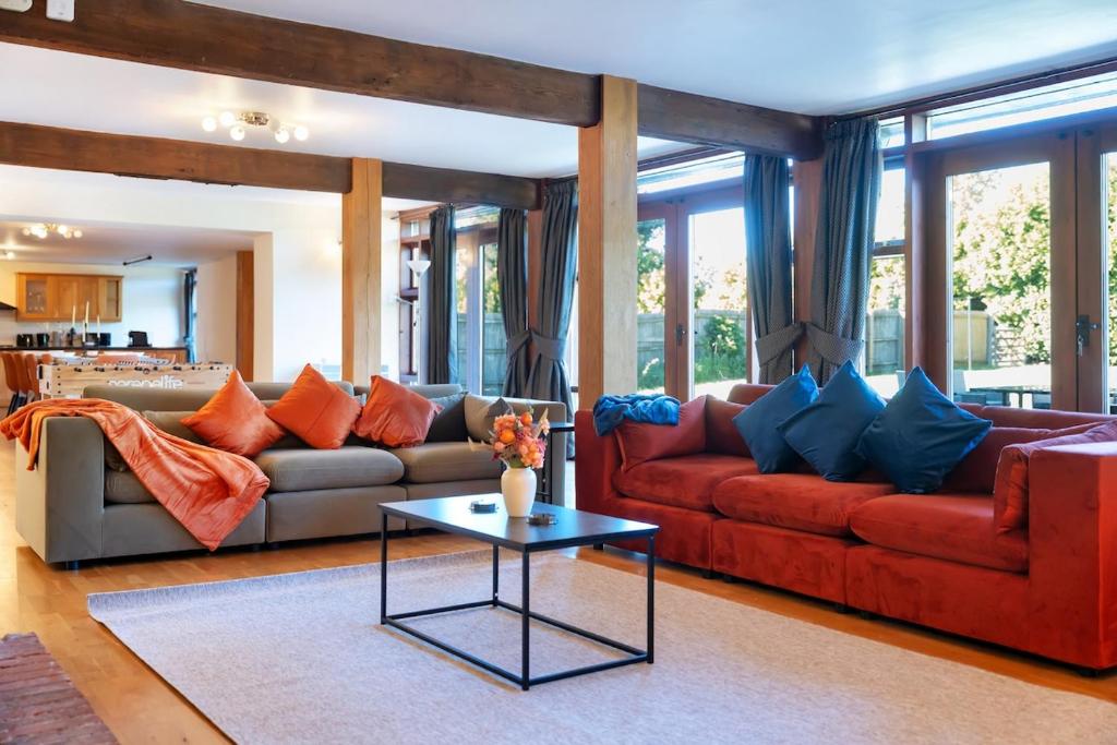 a living room with two couches and a table at Converted Barn - Super King beds, Parking, WiFi in Hockwold cum Wilton