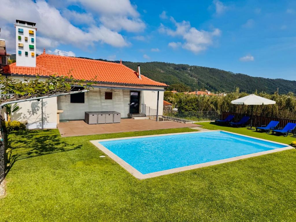 a backyard with a swimming pool and a house at Casa do Cato in Viana do Castelo