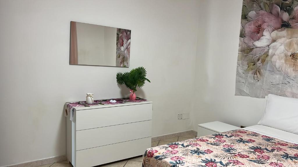 a bedroom with a bed and a dresser with a plant on it at Sogno vesuviano 4 in Torre del Greco