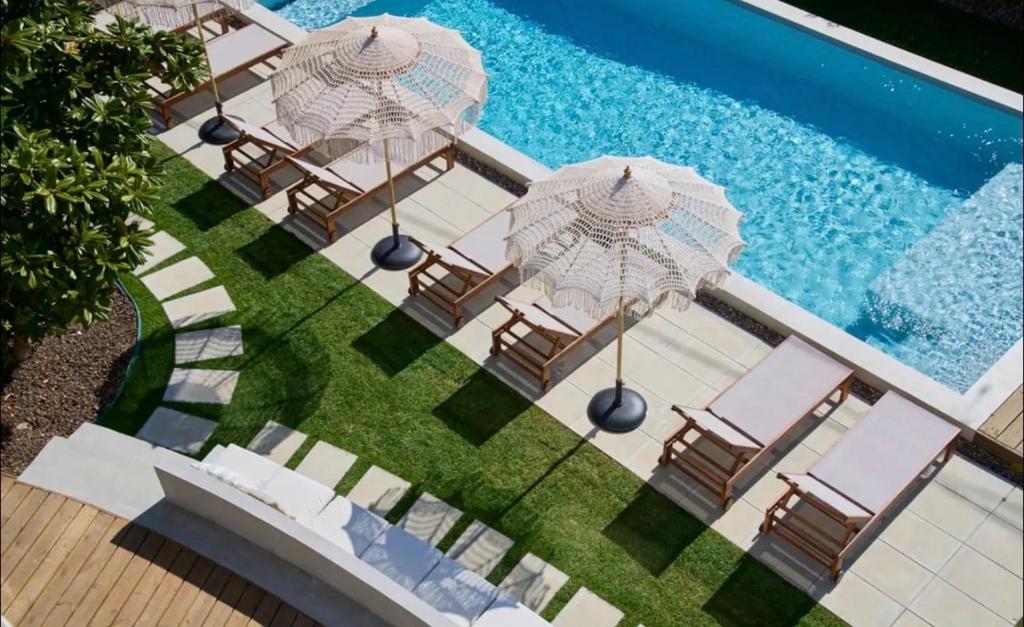 an overhead view of a pool with chairs and umbrellas at Casa Redonda by Villas Aura - Retreat 2 in Aroeira