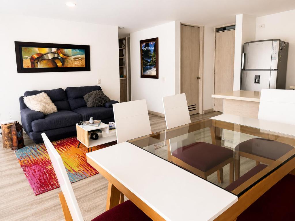 a living room with a blue couch and a table at Comodo Apto Diagonal MALL PLAZA in Manizales