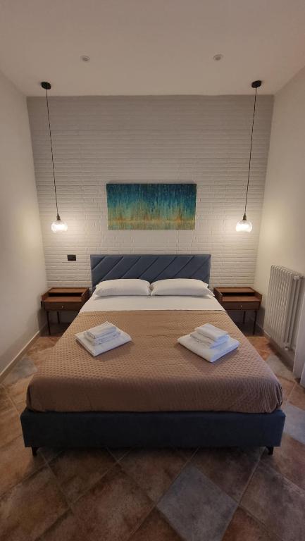 a bedroom with a large bed with two towels on it at DIMORA REALE - Charming House Caserta in Casagiove