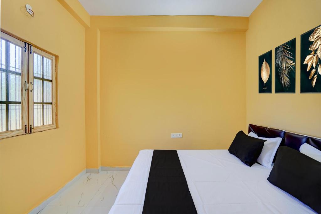 a bedroom with a large bed with yellow walls at SPOT ON Galaxy Hotel in Lucknow