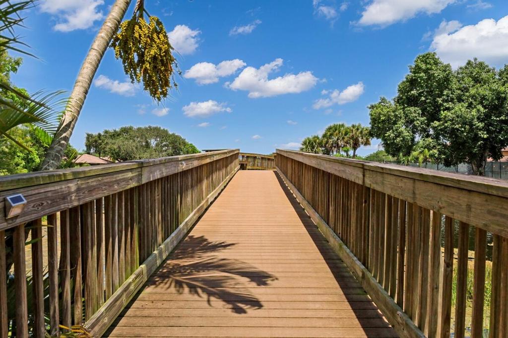 a wooden bridge with a palm tree on it at Pet Friendly-Walk to PGA Resort in Palm Beach Gardens