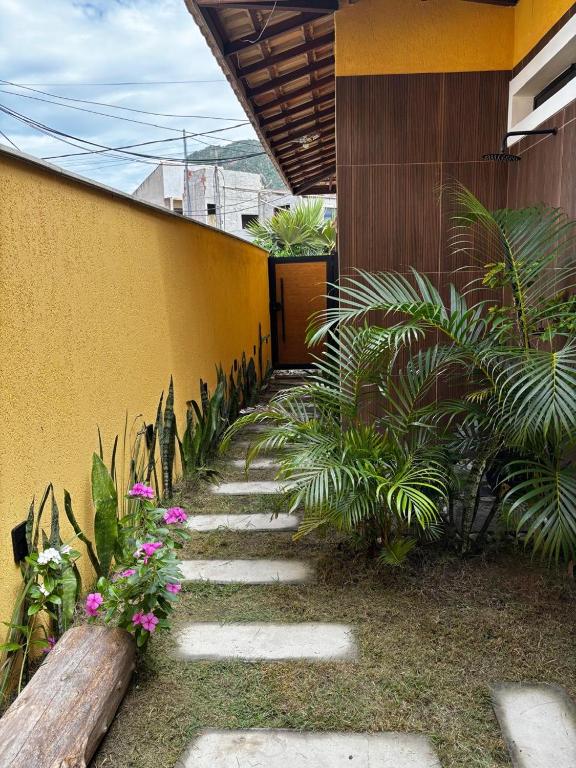 a garden path with plants and flowers next to a building at Recanto Tucuns-Guest House in Búzios