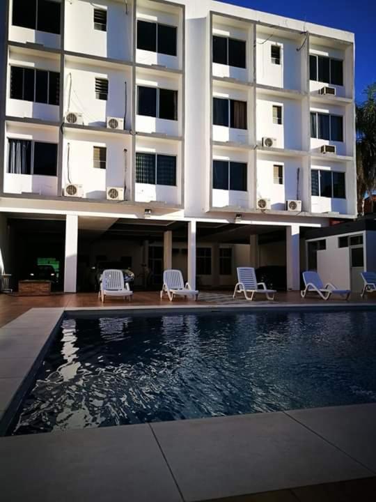 a building with a swimming pool in front of a building at Ibiza Hostel Suites in Santa Cruz de la Sierra
