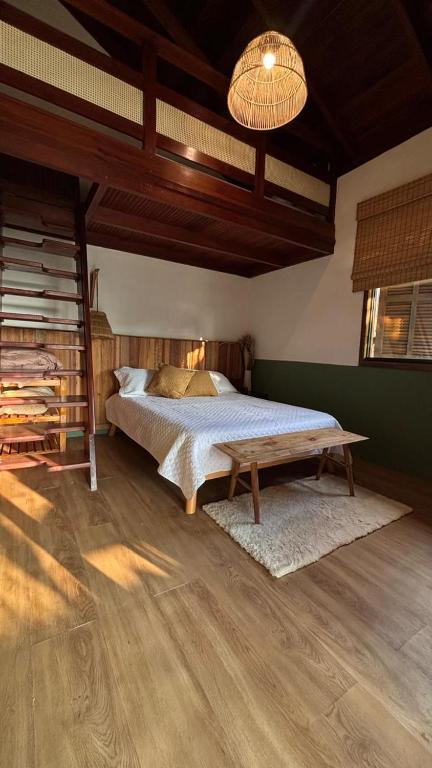 a bedroom with a bed and a wooden ceiling at Chalé na montanha com vista e lareira Mantiqueira in Costas