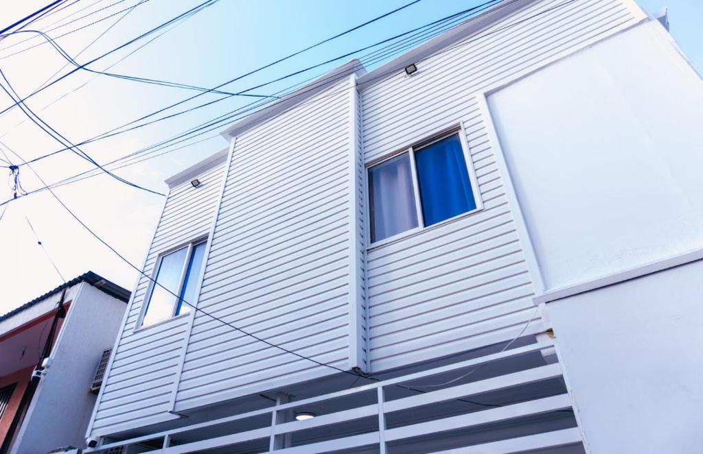 a house with blue windows on the side of it at VILLA SOL HABITACIONES in San Andrés