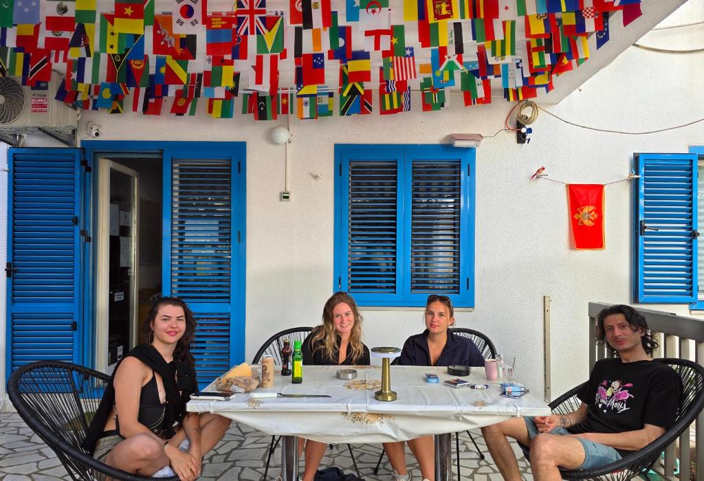 a group of women sitting at a table in front of a building at Hostel Budva in Budva