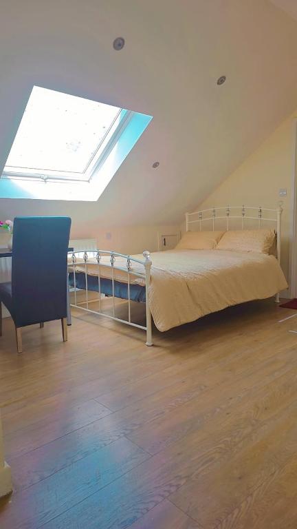 a bedroom with a bed and a skylight at studio with ensuite in New Bedfont