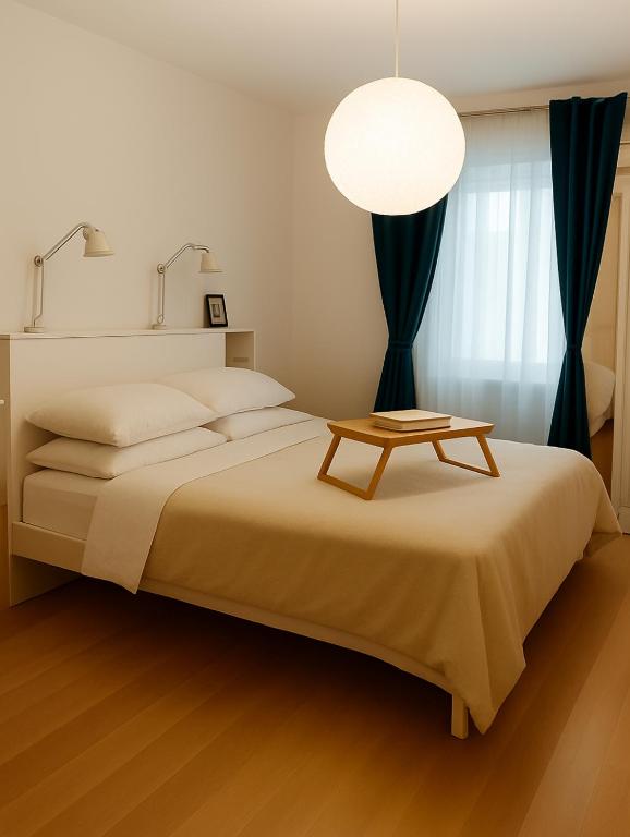 a bedroom with a large bed with a table on it at PepinA'S Home in Martigny-Ville