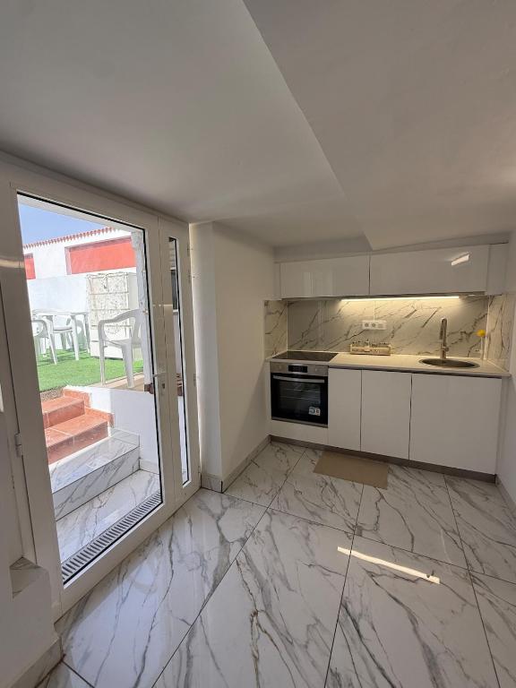 an empty kitchen with a sink and a window at Casa Tul Studio Apartment in Maspalomas