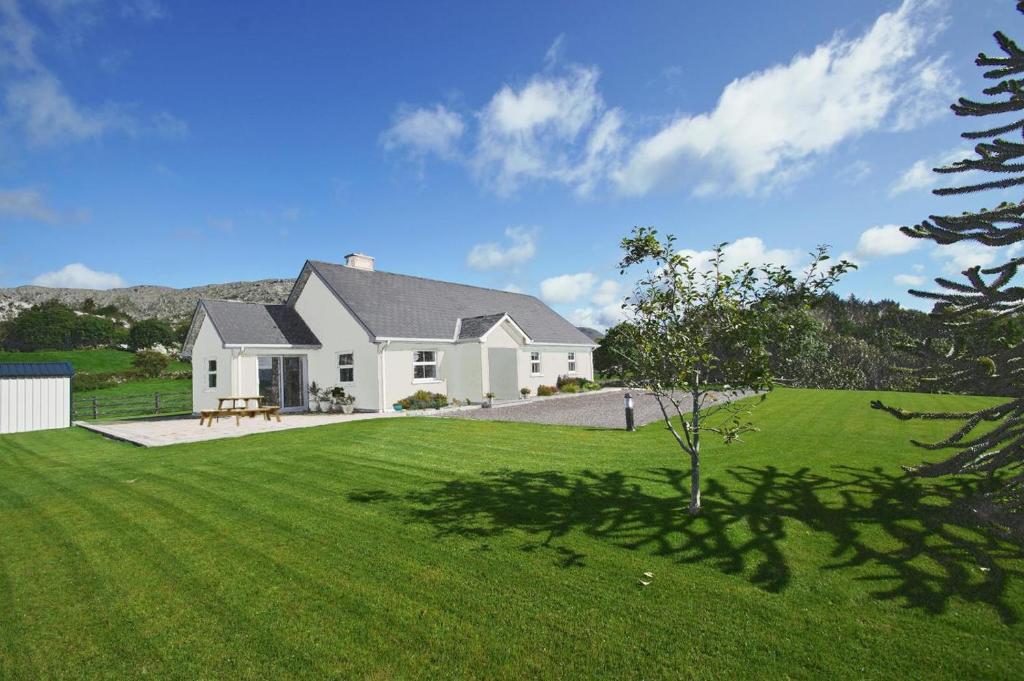 a white house with a green lawn at 4 Bed in Beara oc-i437 in Adrigole