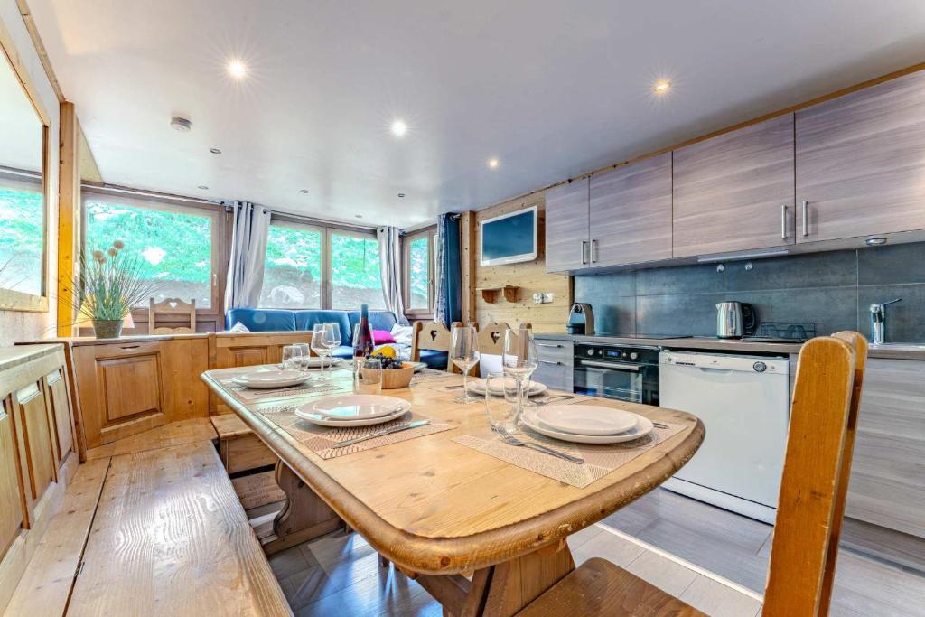 a kitchen with a wooden table with glasses on it at Spacious Ski-In Out apartment with Mountain Views in Val Thorens