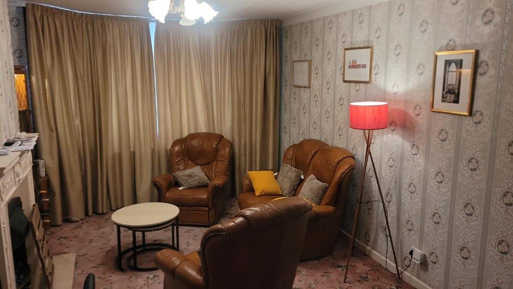 a living room with two chairs and a lamp at Ansty homes in Wyken
