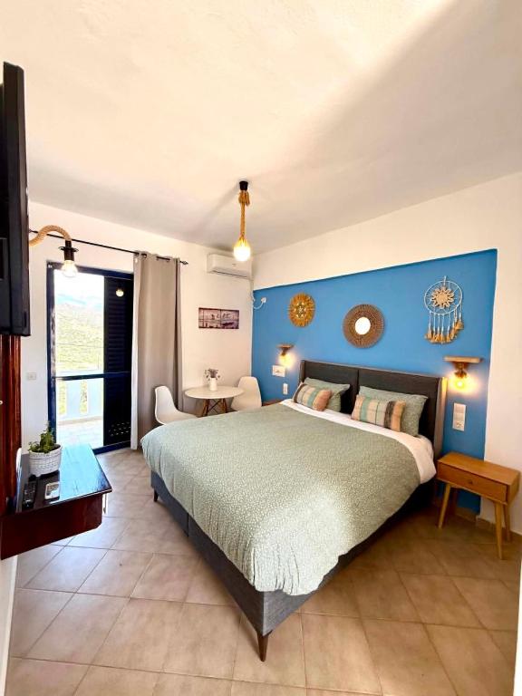 a bedroom with a large bed and a blue wall at Creta Star Apartments in Agia Galini