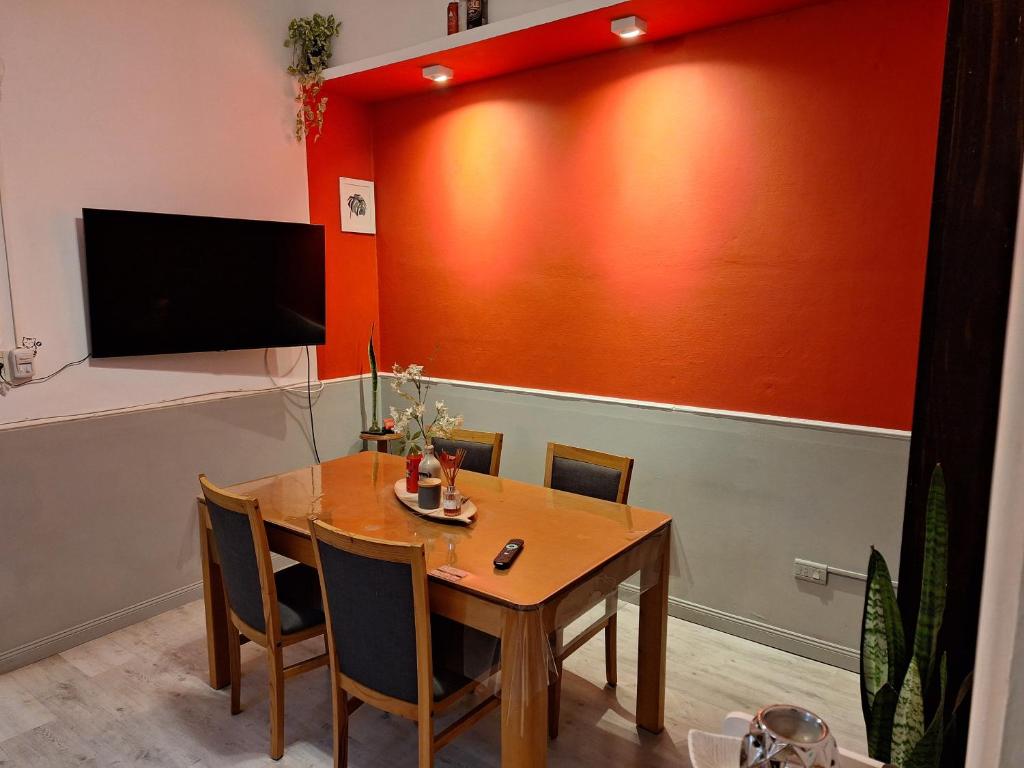 ein Esszimmer mit einem Tisch, Stühlen und einem Fernseher in der Unterkunft LÜr4 in Río Cuarto