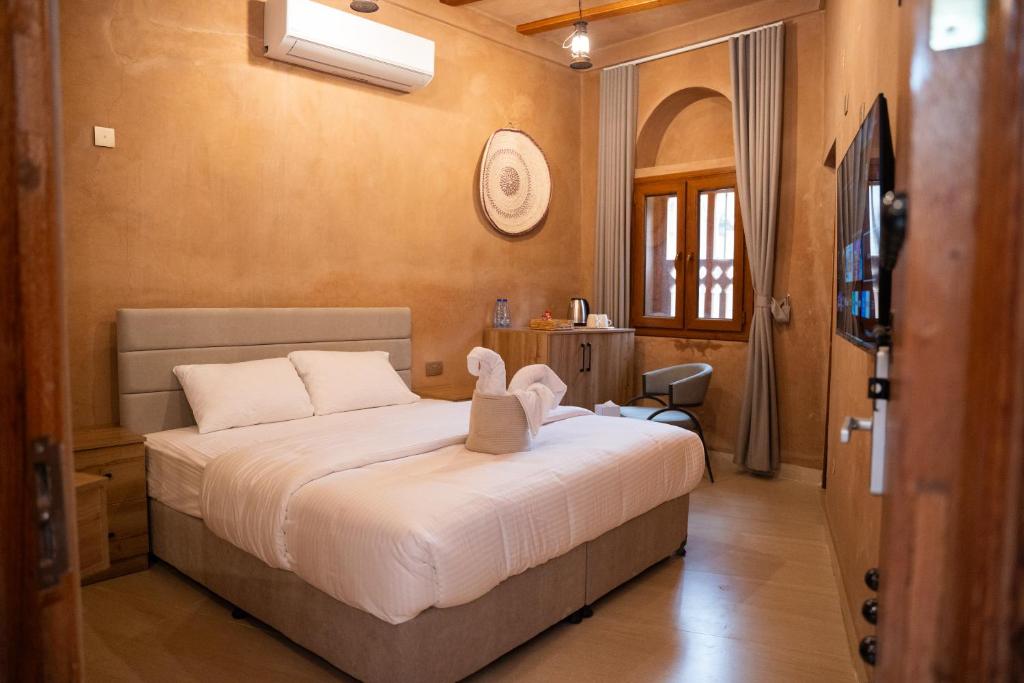 a bedroom with a bed with a stuffed animal on it at بيت المقصرة Almuqasrah house in Nizwa