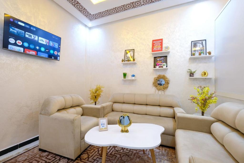 a living room with couches and a table at Riad Bollywood-Golden Stay D in Benguerir