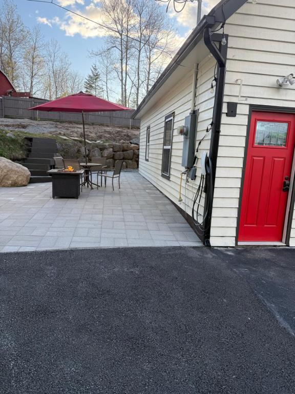a red door on the side of a building with a patio at Modern Home &Cozy in Lake Placid