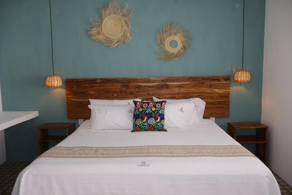 a bedroom with a white bed with blue walls at Hotel Ladrillo in Oaxaca City