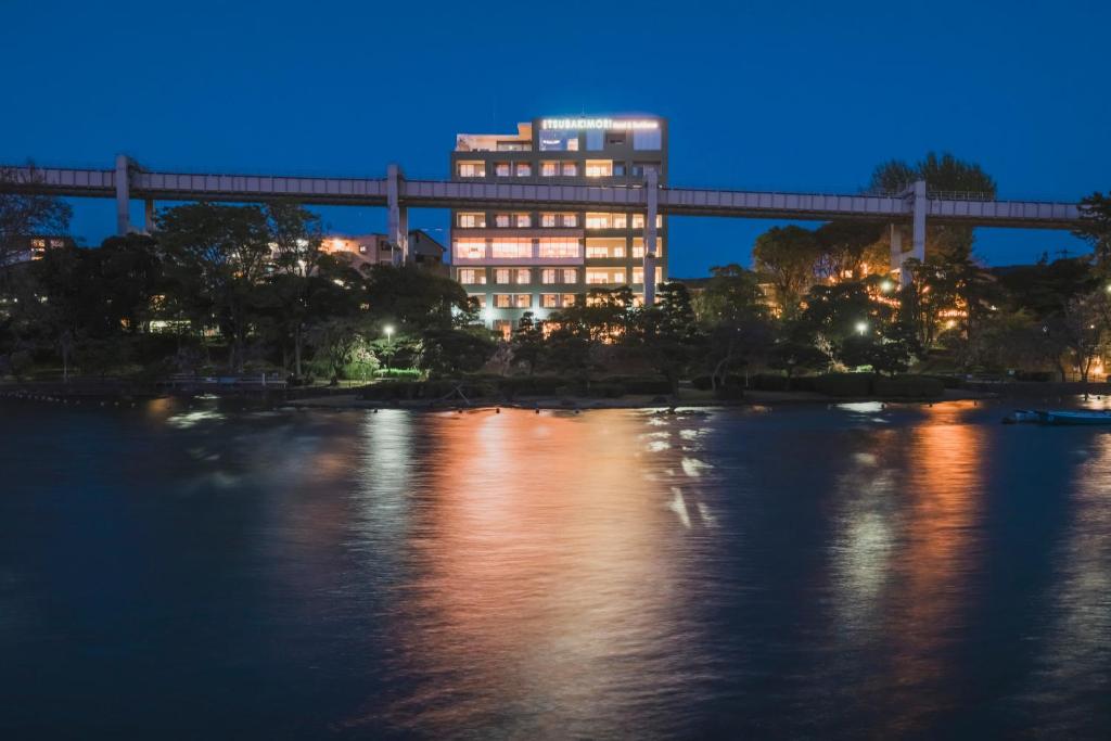a building at night with a bridge over a river at THE TSUBAKIMORI Hotel & Residence in Chiba