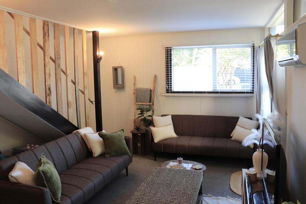 a living room with a couch and a window at Central Nelson Townhouse in Nelson