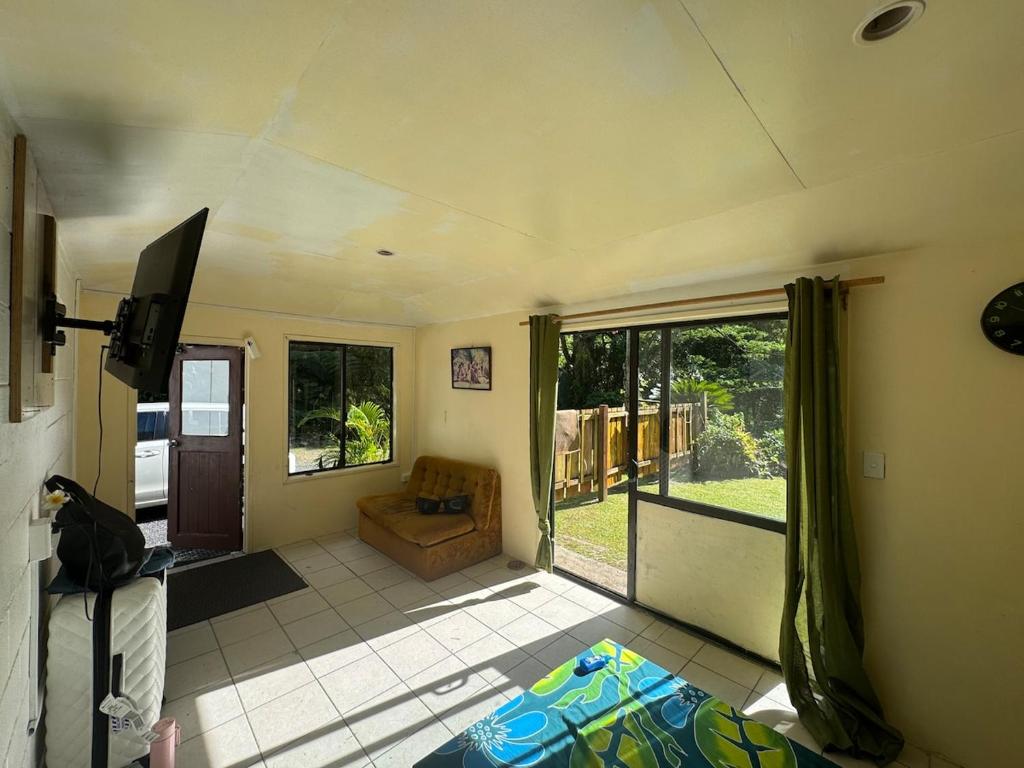 a living room with a couch and a tv at Mama Cat's Accommodation in Avarua