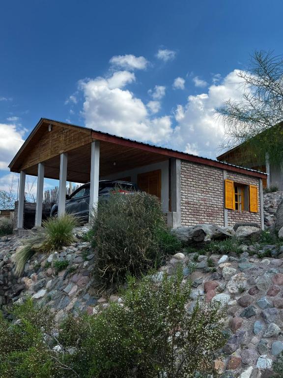 a small brick house with yellow doors on a hill at Vista del Plata - Alojamiento in Potrerillos