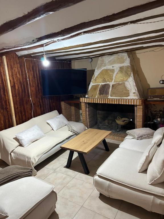 a room with couches and a table and a fireplace at Casa Castillo in Moratalla