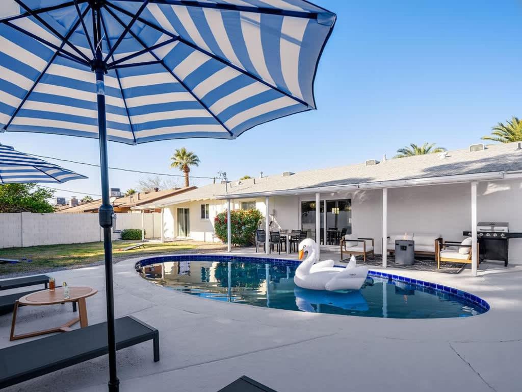 a swan swimming in a pool with an umbrella at Sweet Serenity-Private Pool-8 Mins to Old Town in Scottsdale