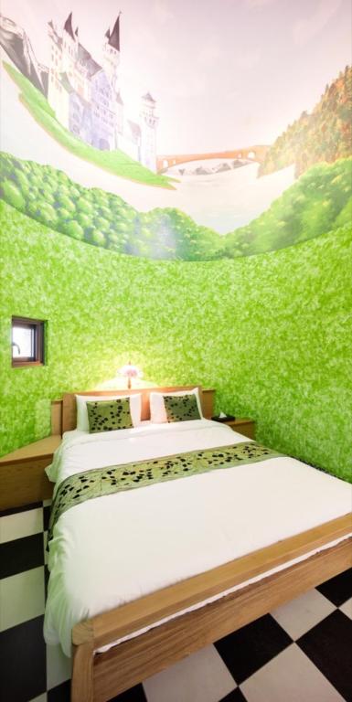 a bedroom with a green wall with two beds at Zum Adler Castle B&amp;B in Jiaoxi