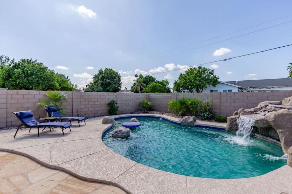 a swimming pool with a waterfall in a backyard at Azure - Sparkling Pool - Pool Table - In Old Town in Scottsdale