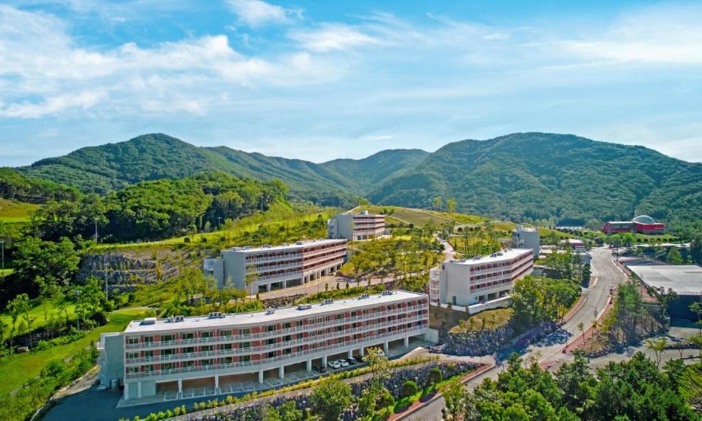 an aerial view of a building with mountains in the background at Belle Fore Resort in Jeungpyeong
